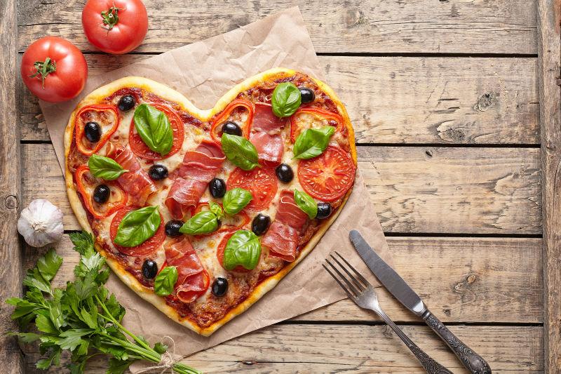 老式木桌上的心形披萨饼