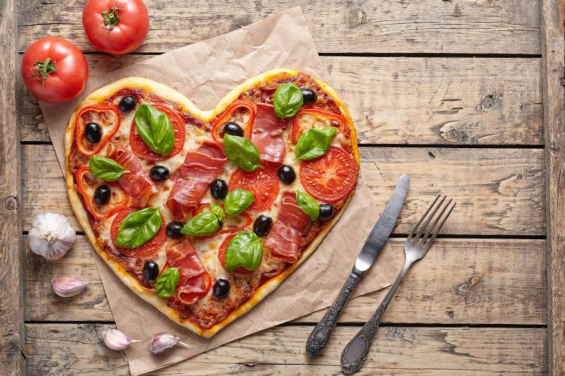 老式木桌子上的心形披萨饼