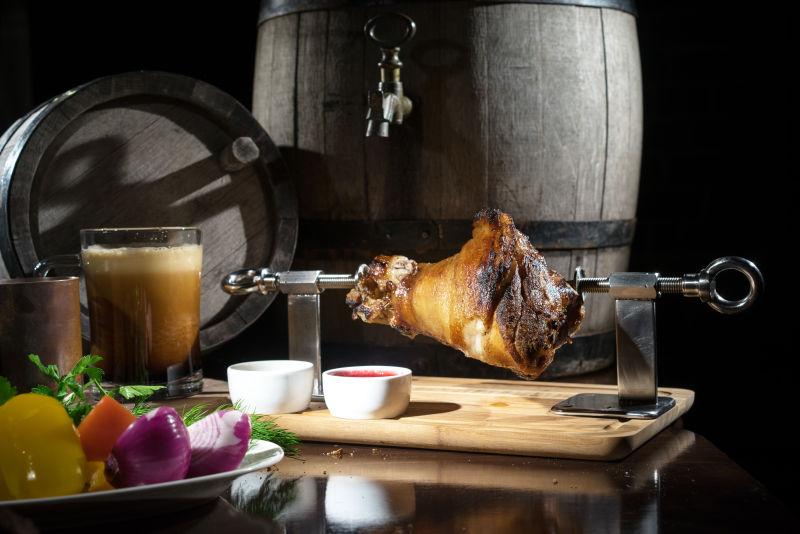 猪肘美食旁的各种蔬菜和啤酒