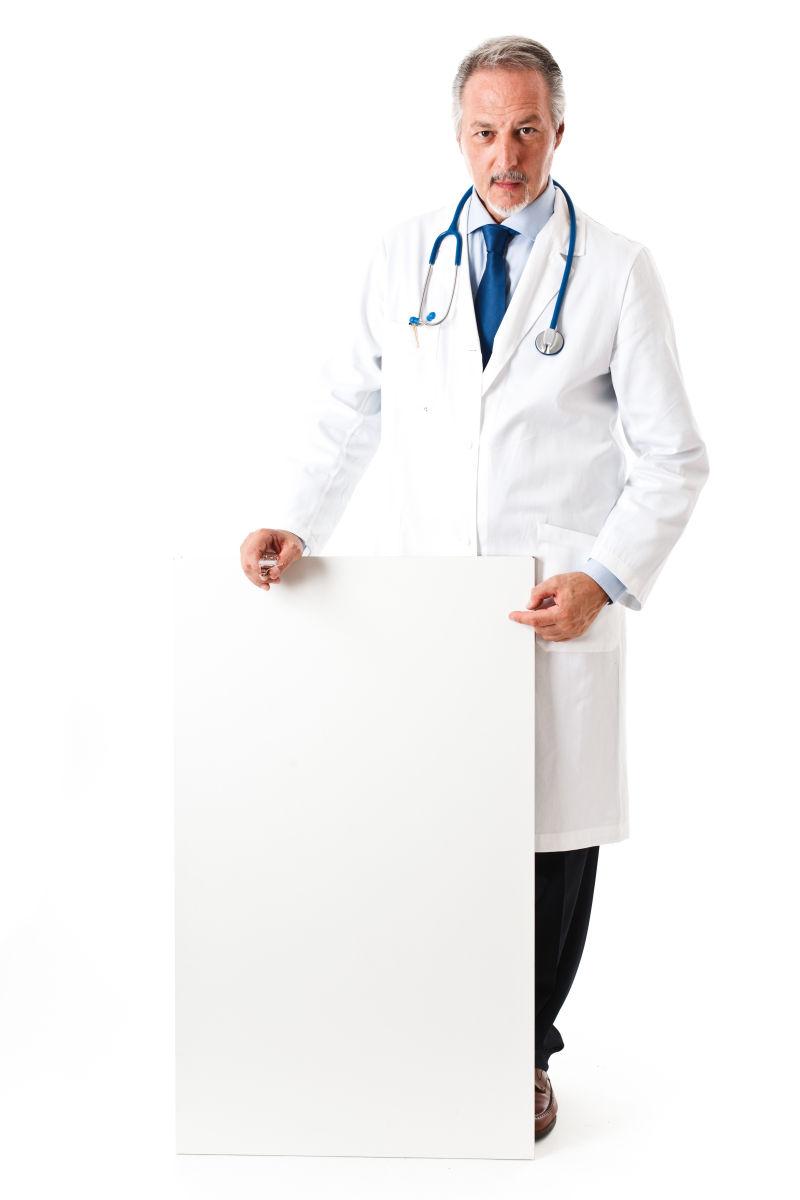 白色背景下拿白色木板的男医生