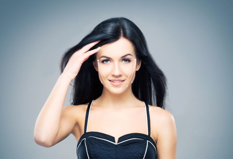 灰色背景上一个脸上画着箭头的黑发女人