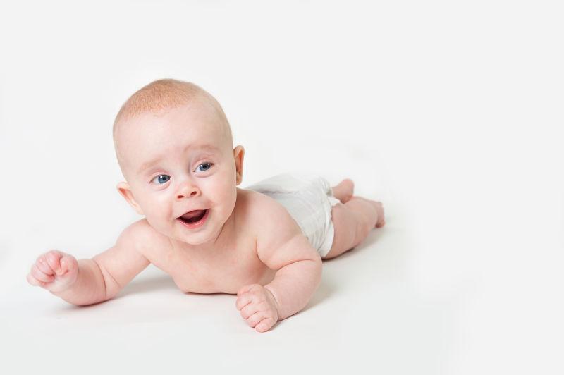 白色背景下趴着的有趣的小婴儿