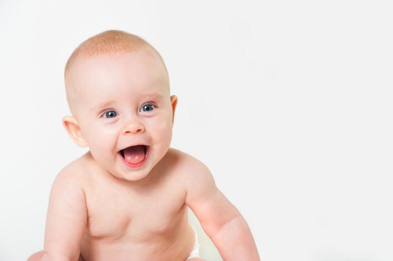 白色背景下张嘴笑的快乐的小女婴肖像