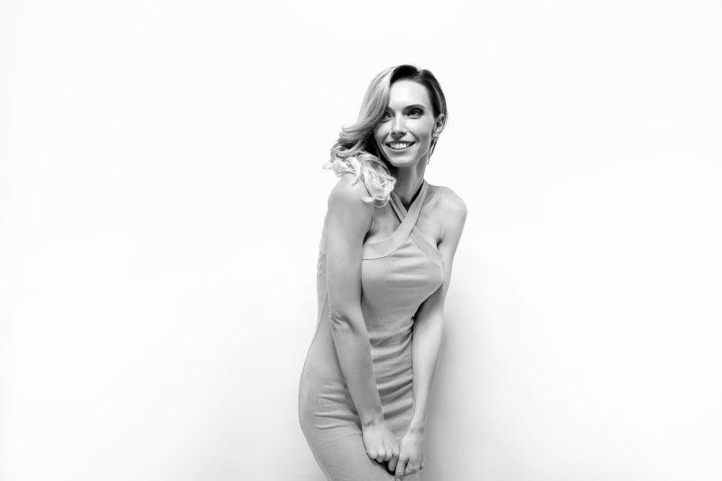 微笑的金发女郎在灰色背景下