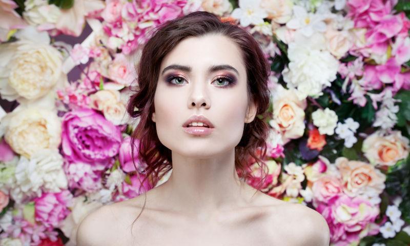 花墙前面抬起头的年轻美女