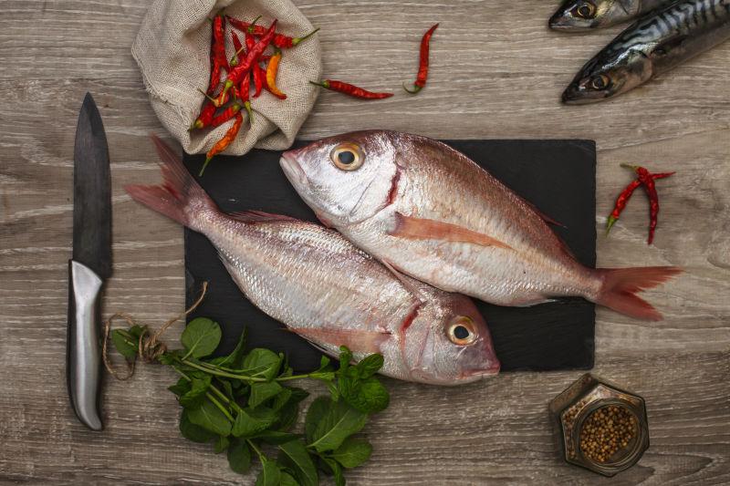 有刀和案板的新鲜生鱼及香料