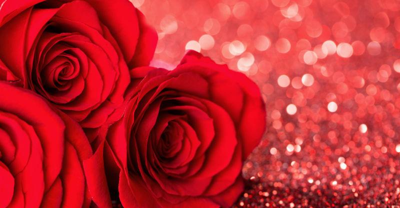 红色闪亮背景中的三朵红玫瑰