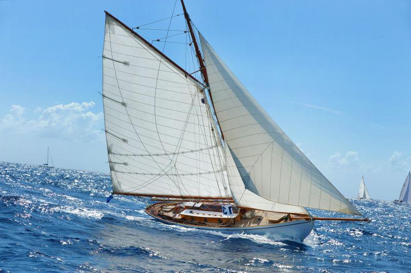 蓝天下蓝色的海面上行驶的白色帆船