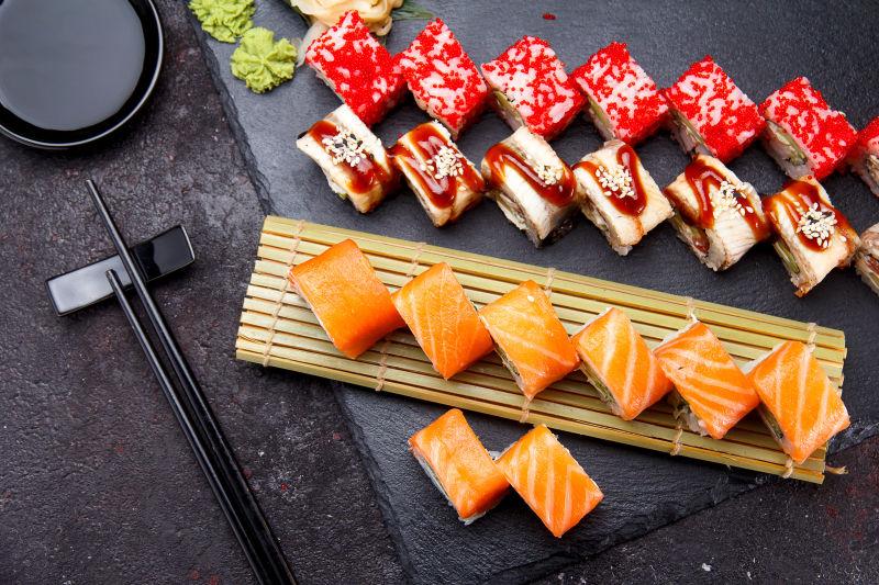 寿司用新鲜配料滚在石板的背景上