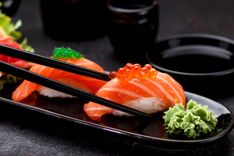 在黑板上用筷子夹三文鱼寿司