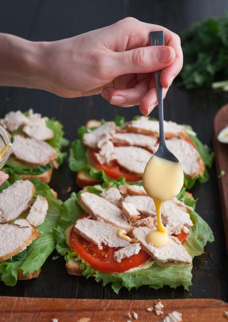 在蔬菜上放沙拉的厨师