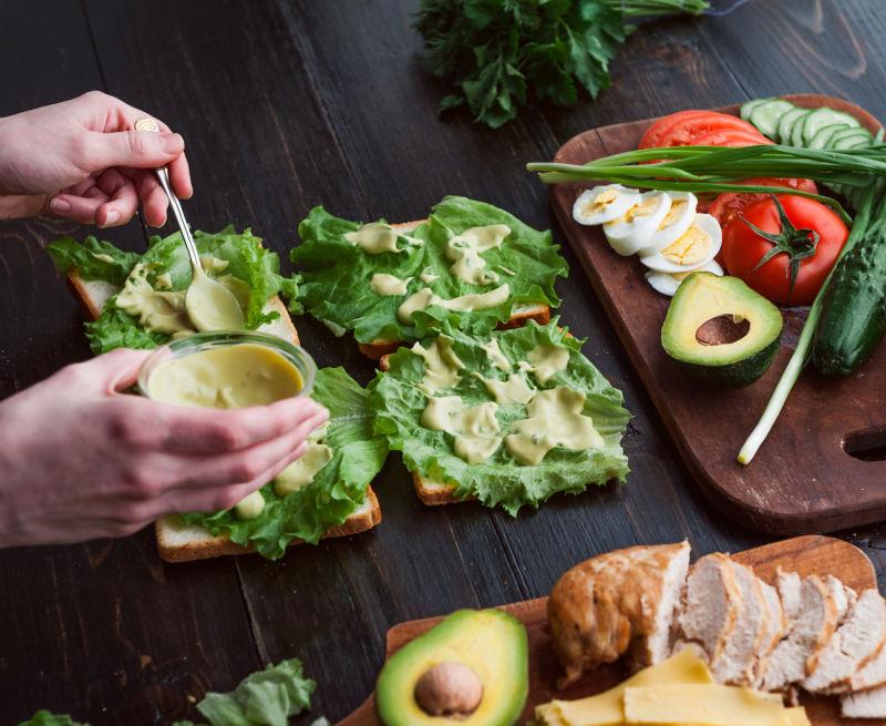 木制桌面上的做三明治的人