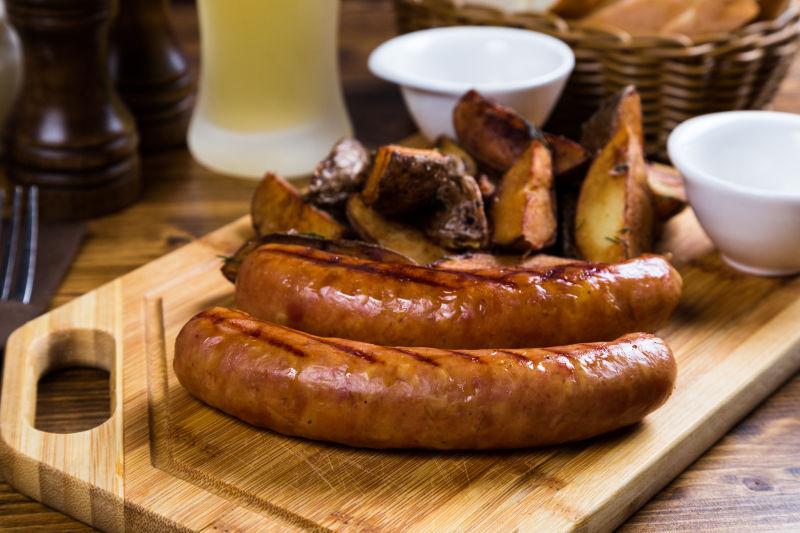 砧板上的烤香肠和烤土豆