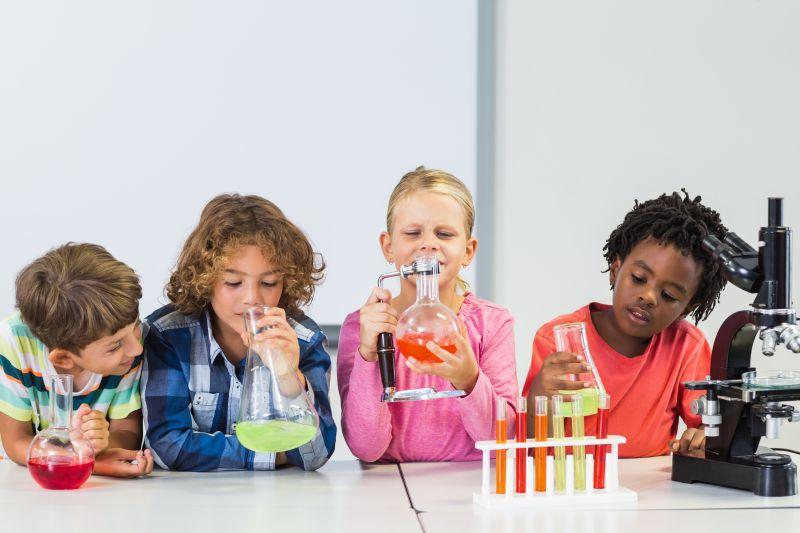 做化学实验的孩子拿着烧杯