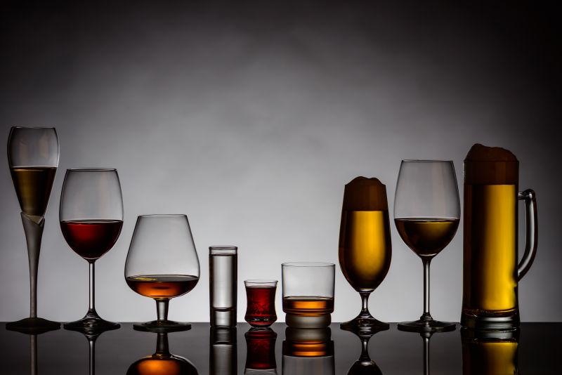 灰色背景上不同啤酒杯里的啤酒
