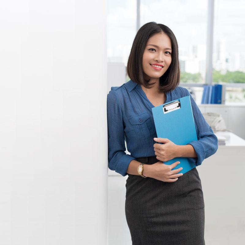 办公室背景中微笑的年轻女职员