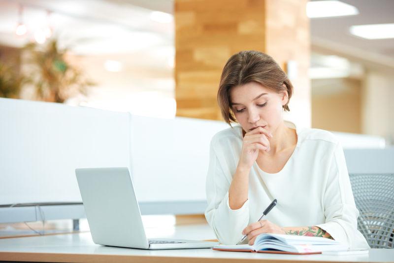 咖啡店对着笔记本做记录的女职员