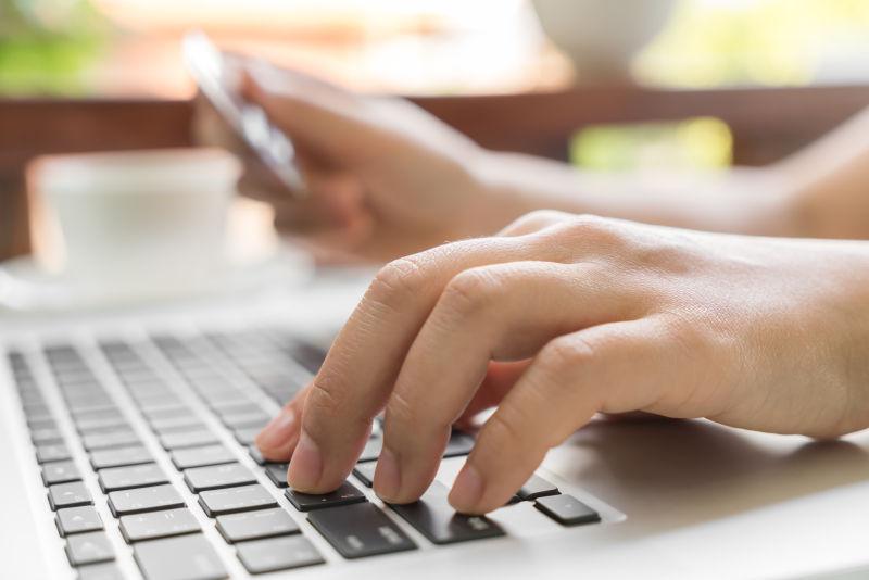 手持信用卡并使用笔记本电脑进行购物