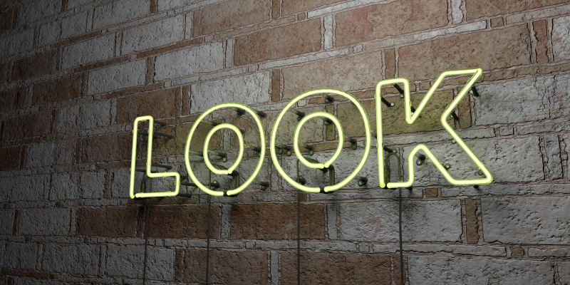 看霓虹灯招牌在石墙上