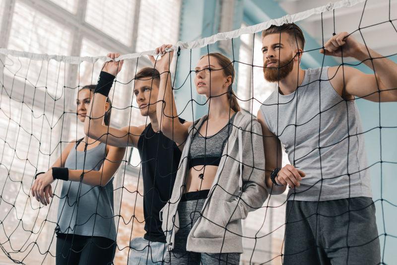 年轻的运动员在体育场馆看排球网