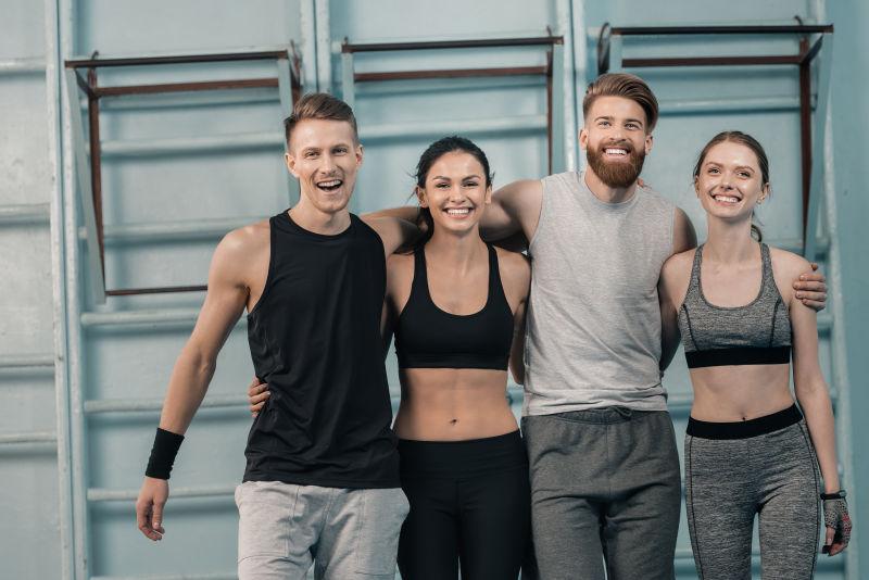 男女运动员在健身房里微笑