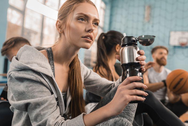 年轻的美女运动员在喝水