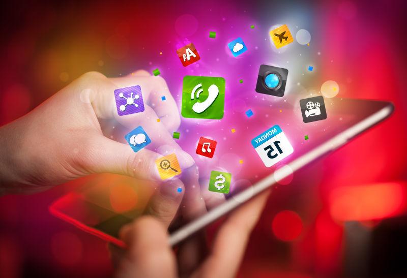 暗红色背景下的触摸式平板电脑上的彩色社会媒体图标