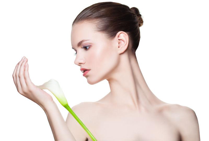 白色背景上拿着百合花的美女