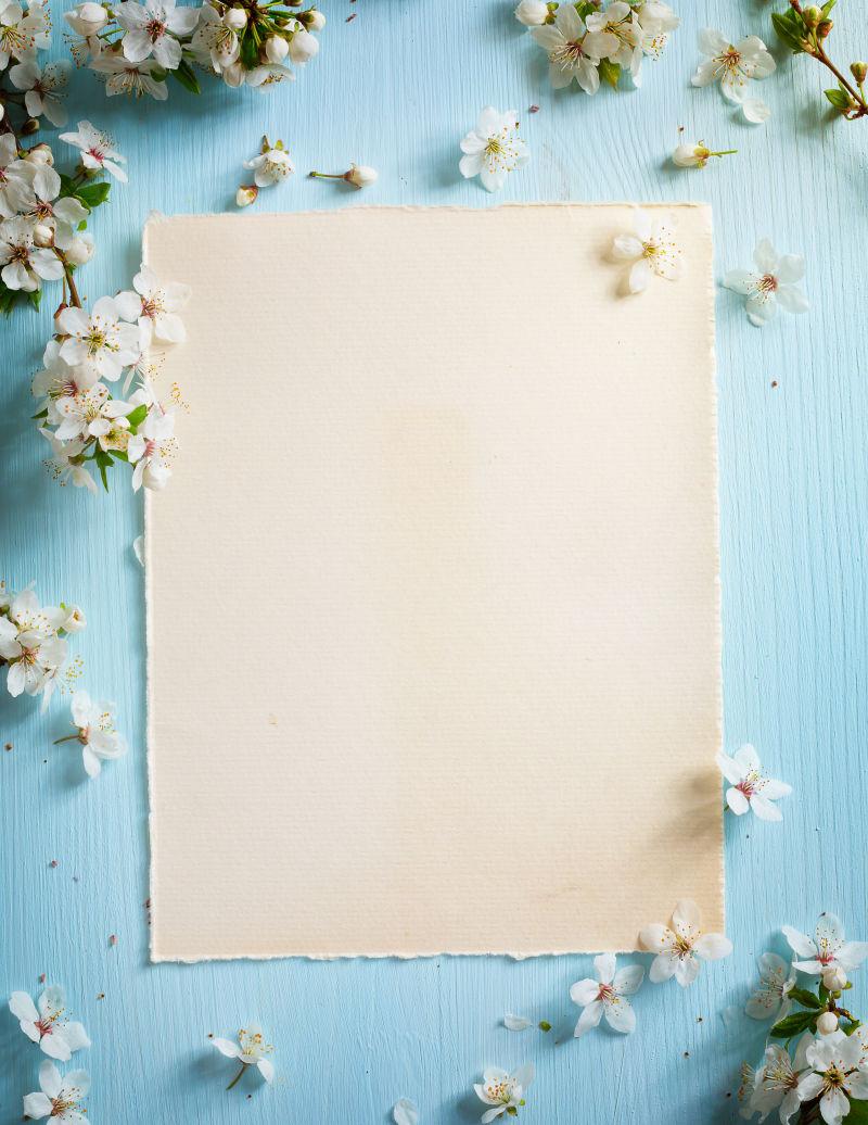 蓝色木板上的白纸和花朵