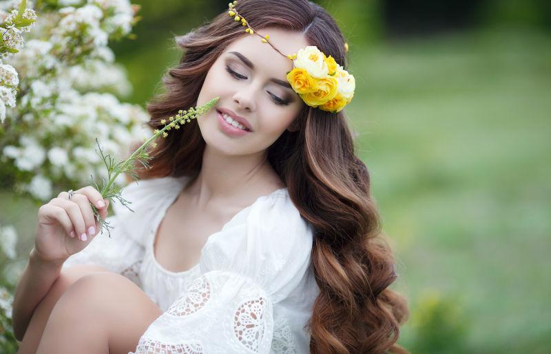 年轻的长卷发美女戴着黄色花环