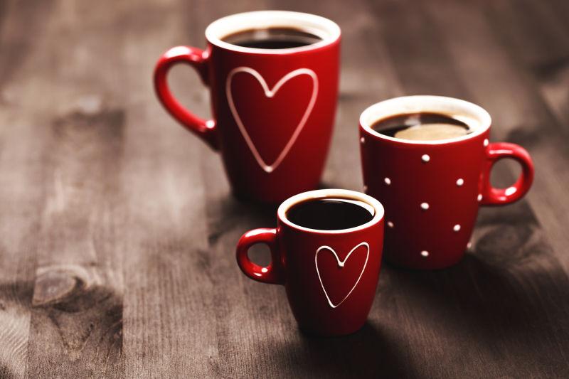 木制背景中三杯红色心形咖啡