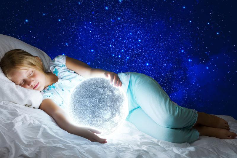星空背景前抱着月球睡觉的小女孩