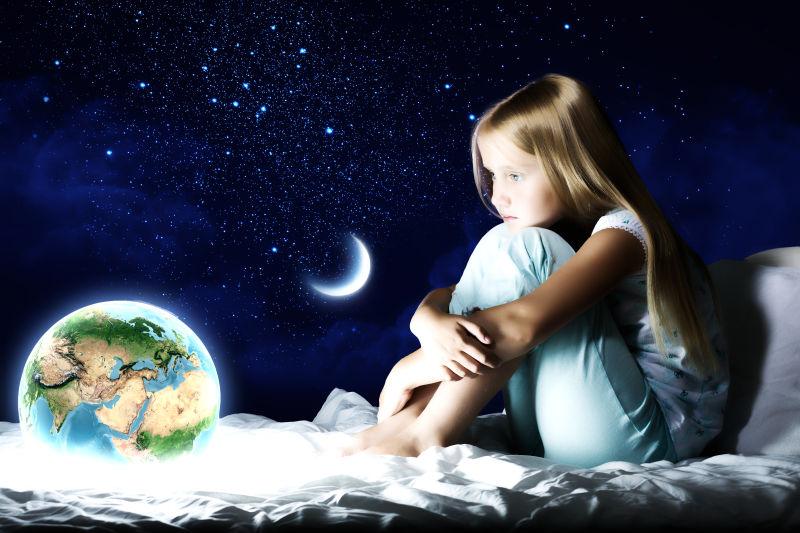 地月系星空与坐在床上的小女孩