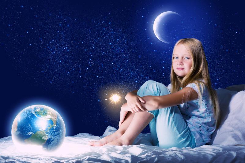 坐在床上的快乐的小女孩和星空