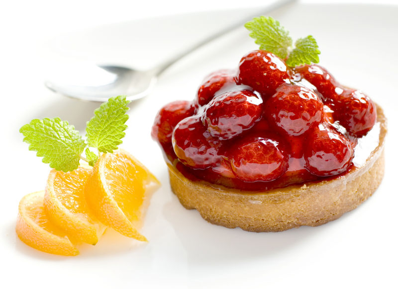 白色盘子上的草莓浆果甜点和柠檬片