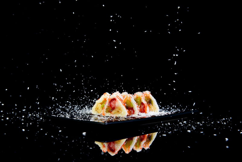 黑色背景上美味的三角水果面包卷