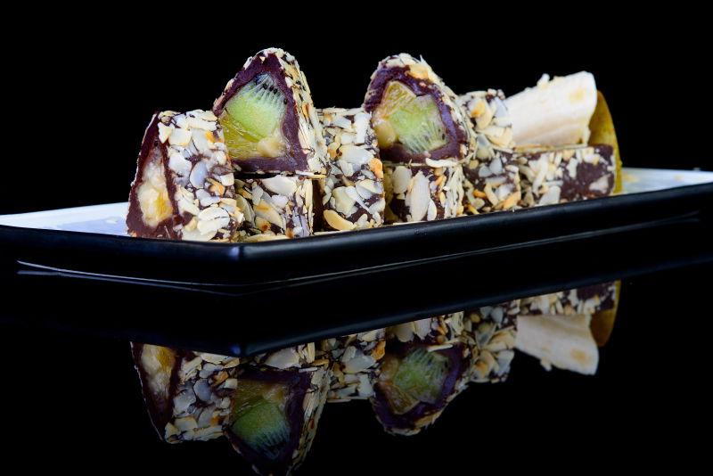 黑色背景上一盘三角水果面包卷