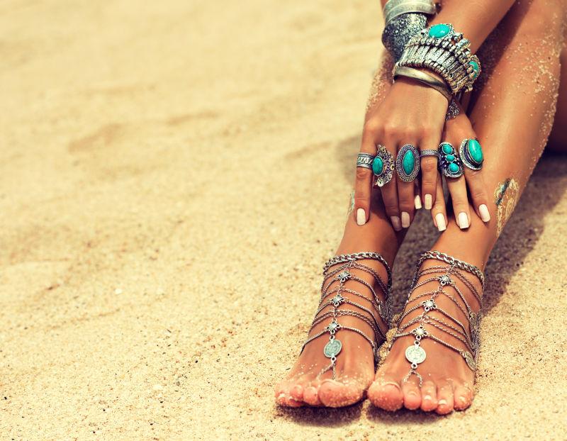 妇女脚和手在热带沙滩上