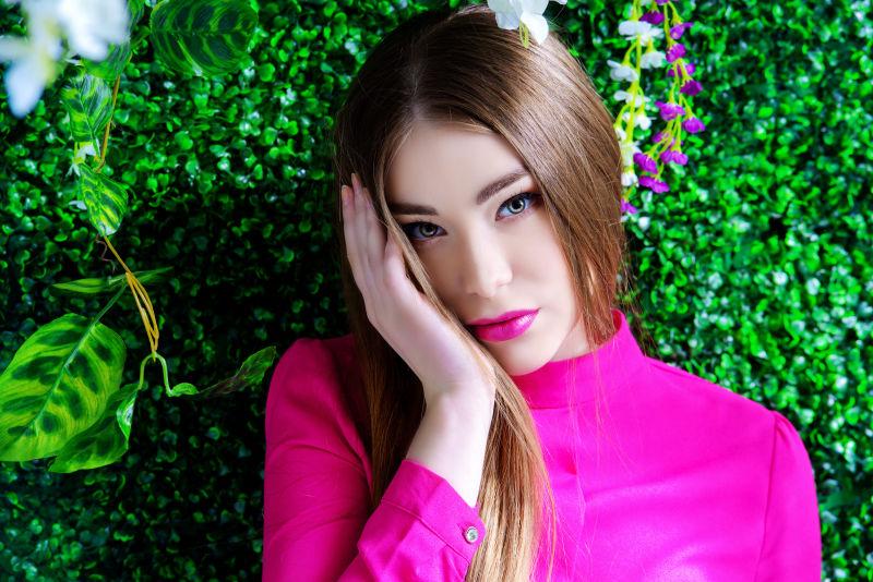 绿色植物前的年轻女孩