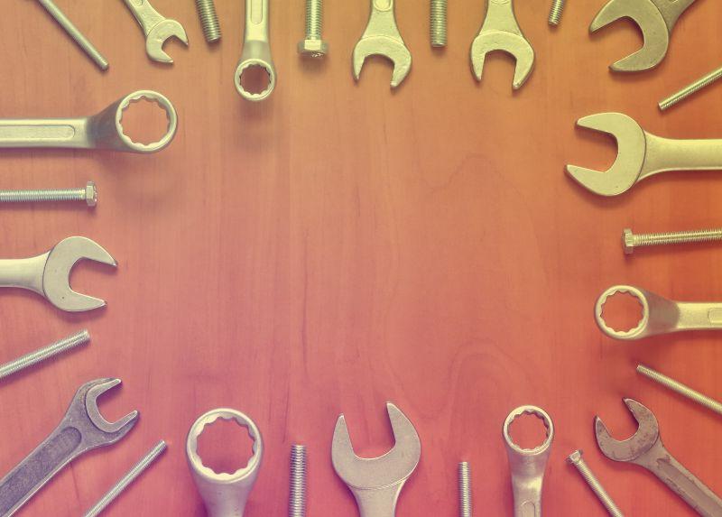 放在木板上的大小不同的扳手和螺丝钉