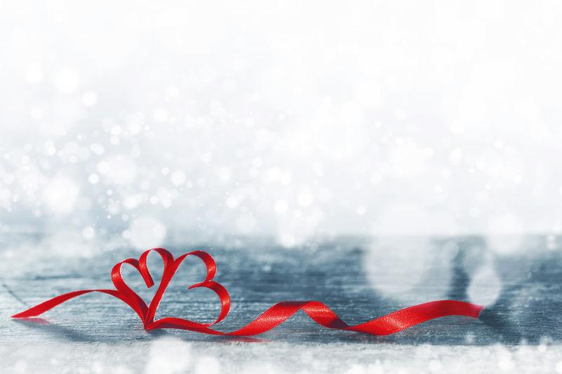 模糊背景中的红色绸带心