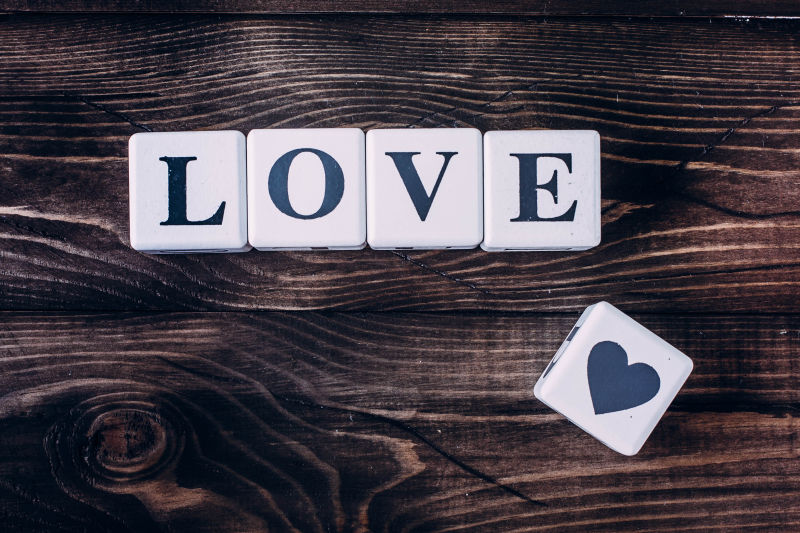 木制背景下的信息爱在木块上拼写