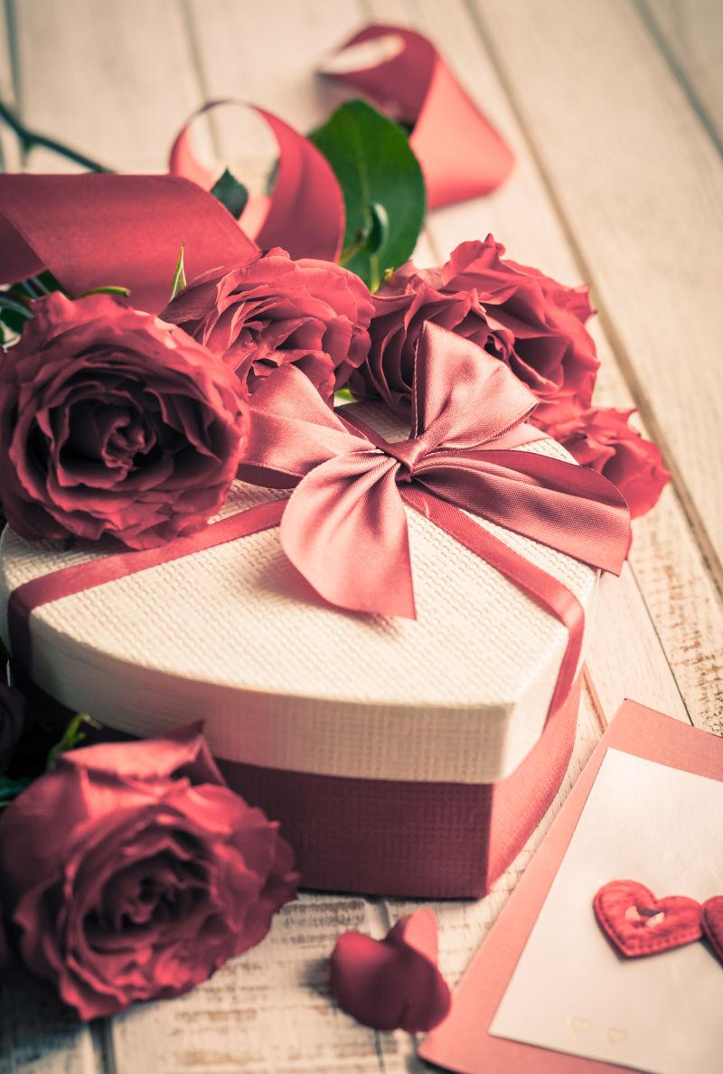礼品盒和玫瑰花束度假的木制背景