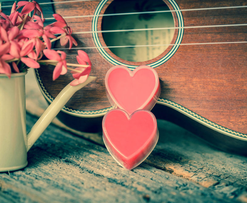 旧木桌上情人节爱心与吉他背景