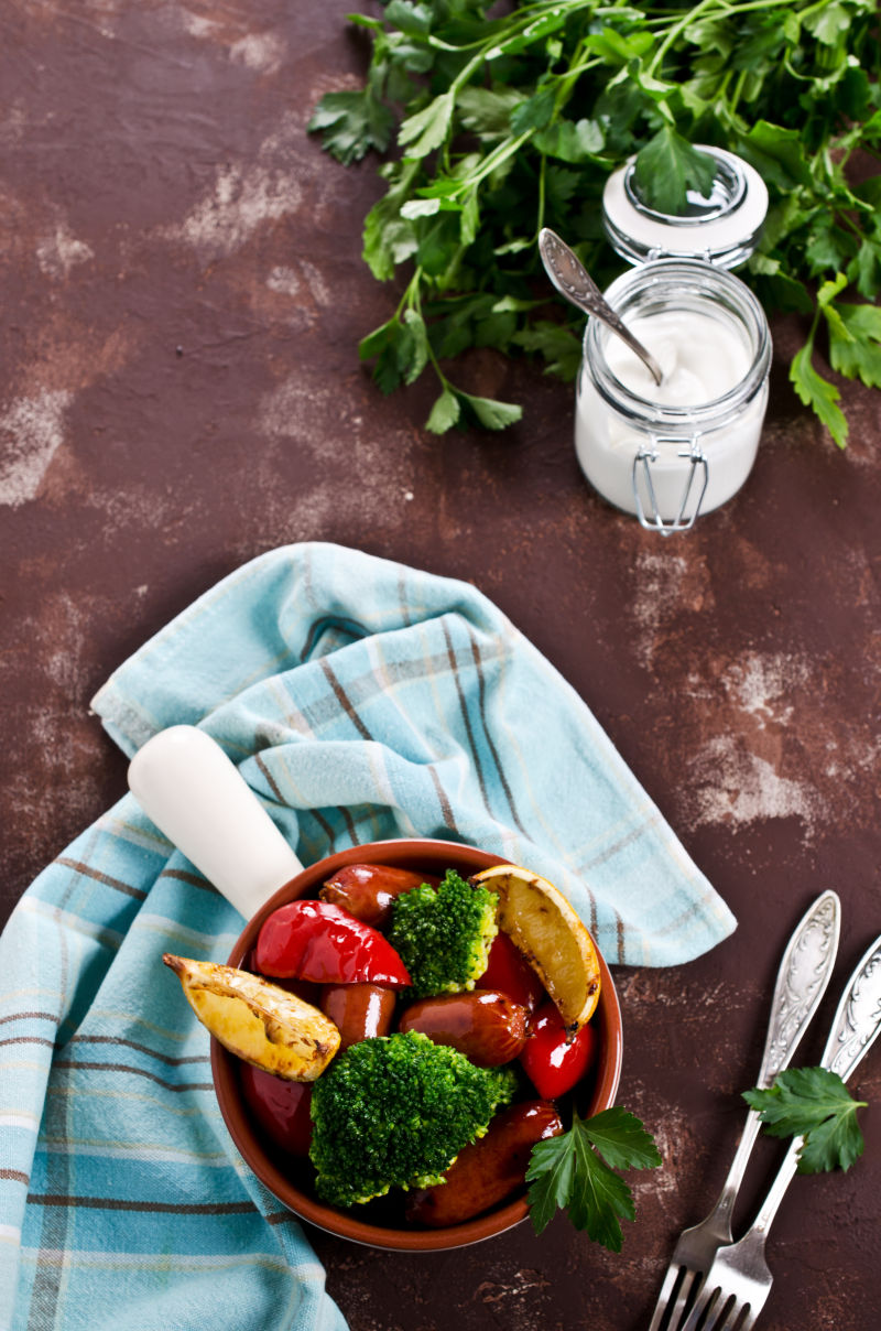 棕色桌面上的香肠与西兰花