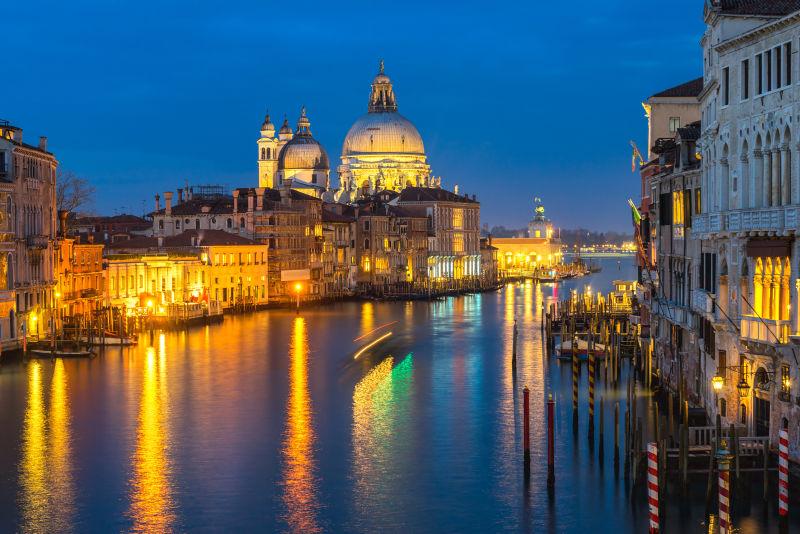 夜幕时分威尼斯大运河旁灯火辉煌的的圣玛丽亚教堂