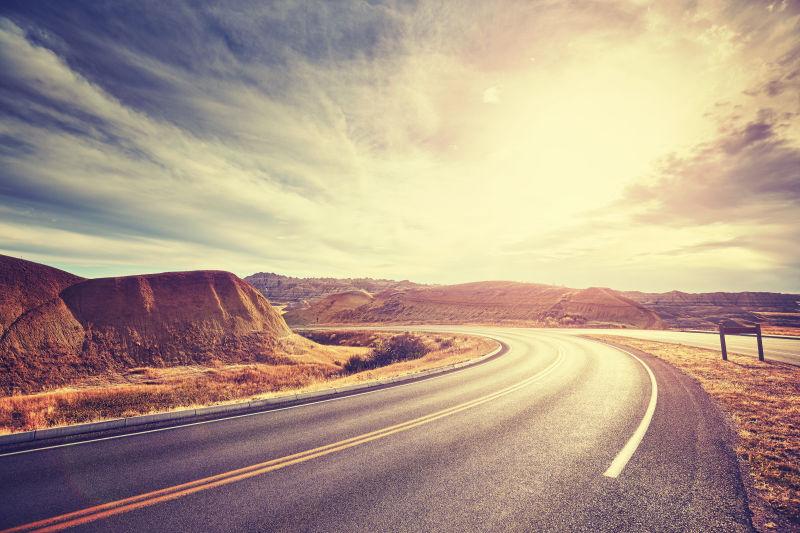 日落时分蓝天白云下的沙漠公路