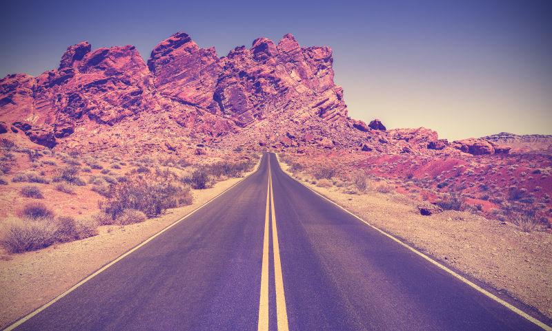 蓝天下群山中的内华达州石漠沙漠的复古风格道路