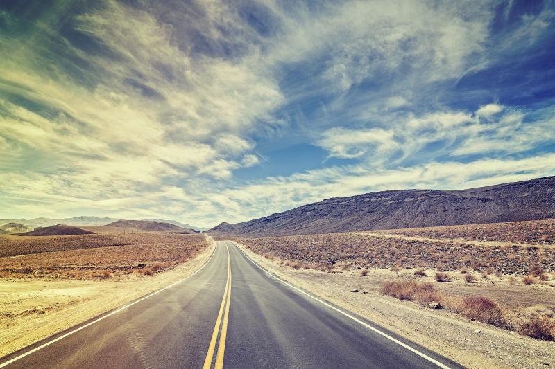 蓝天白云下的复古电影风格美国无尽的乡村公路