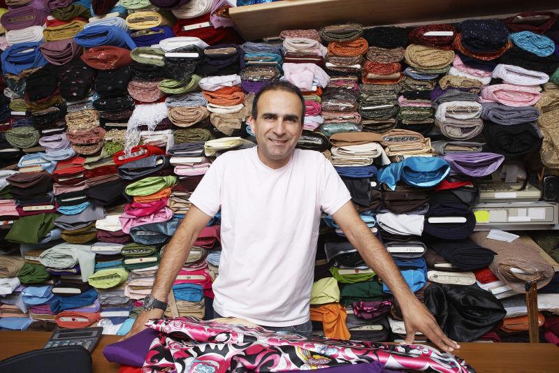 自信布料店老板立在柜台上的肖像